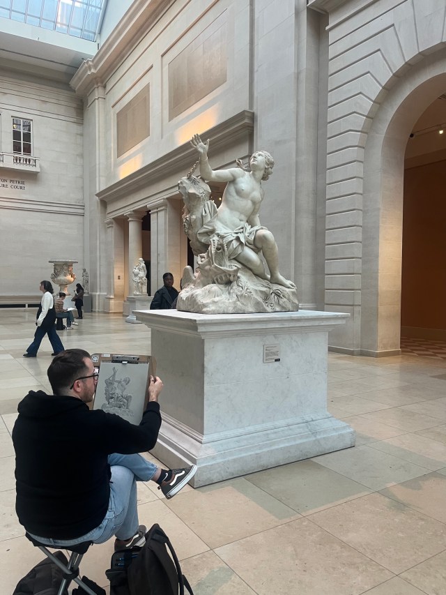 A man sketching a sculpture at the Met